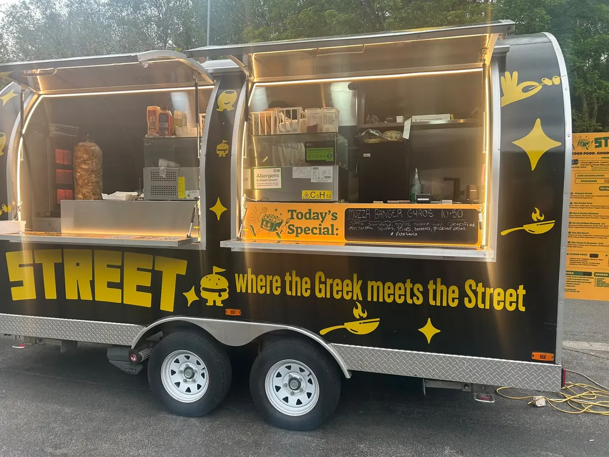 The STREET van set up and lit at dusk, hatch open and ready to serve